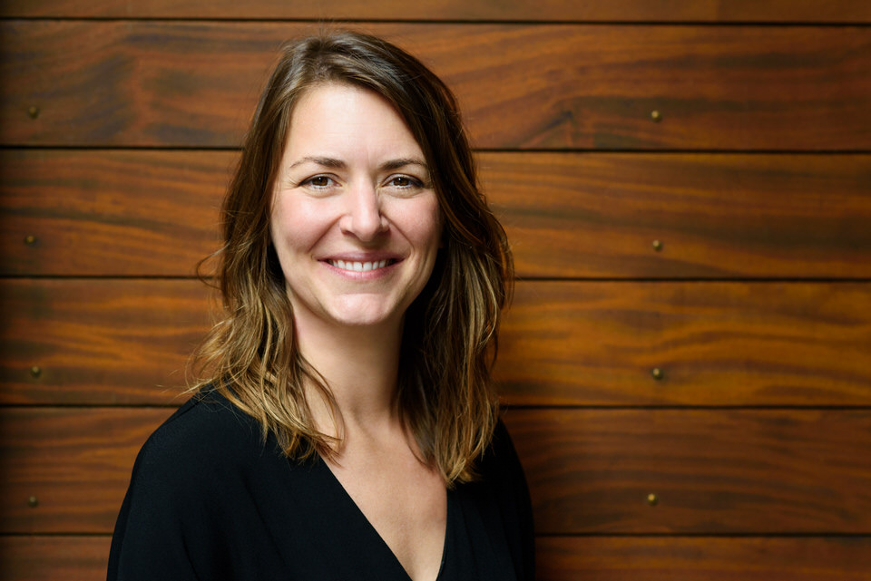 Woman's headshot against a wooden wall